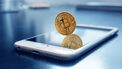 Crypto trading concept; bitcoin balanced on a smartphone